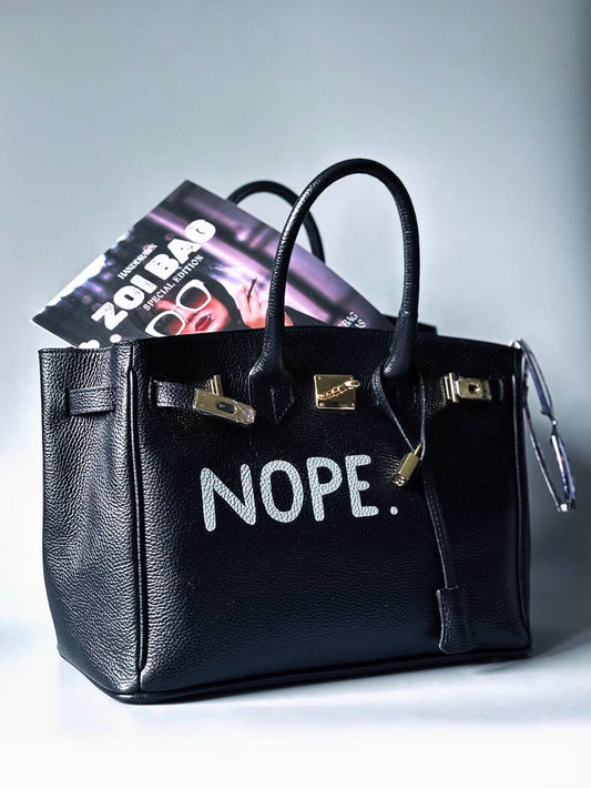 Černá kožená kabelka Zoi Bag s ručně psaným nápisem z pravé italské kůže se zapínáním pomocí ikonického zámku s klíčkem.