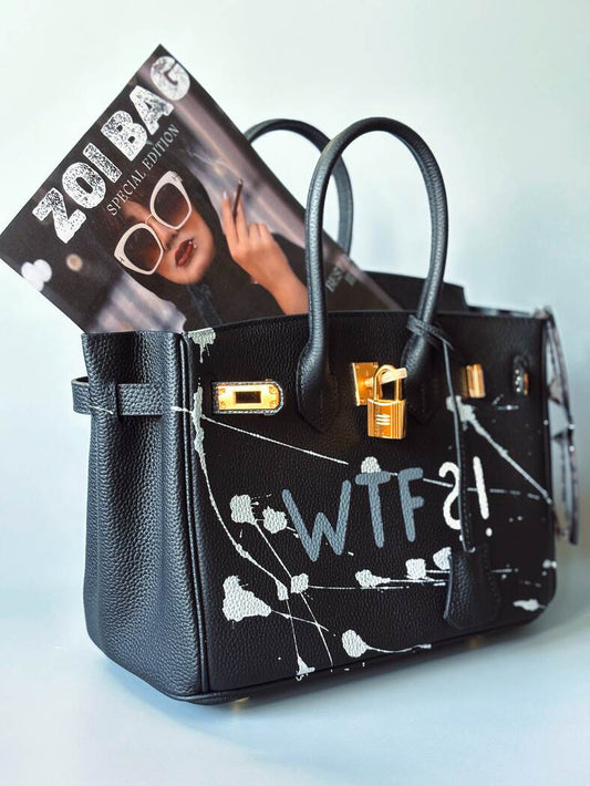 Designová černá kožená kabelka Zoi Bag z právé kůže s ručně psaným nápisem a cákanci barvou. Zlatý zámek s klíčkem.