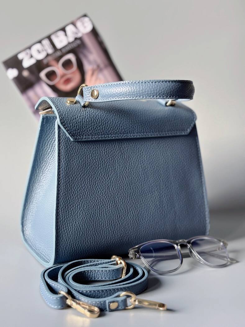 Designová modrá kožená kabelka Zoi Bag s ručně psaným nápisem a s cákanci barvou. Zapínání pomocí otočného zlatého zámku. Zezadu.