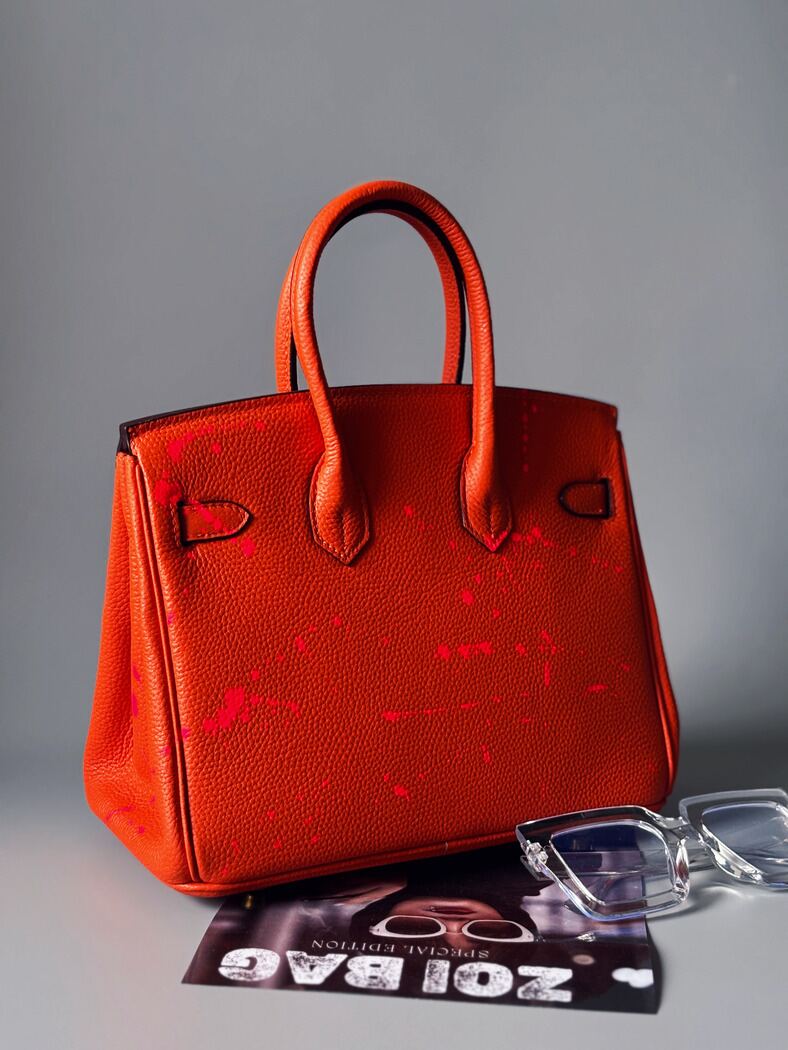 Kožená kabelka Zoi Bag v oranžové barvě s nápisem "No desire to fit in" zezadu