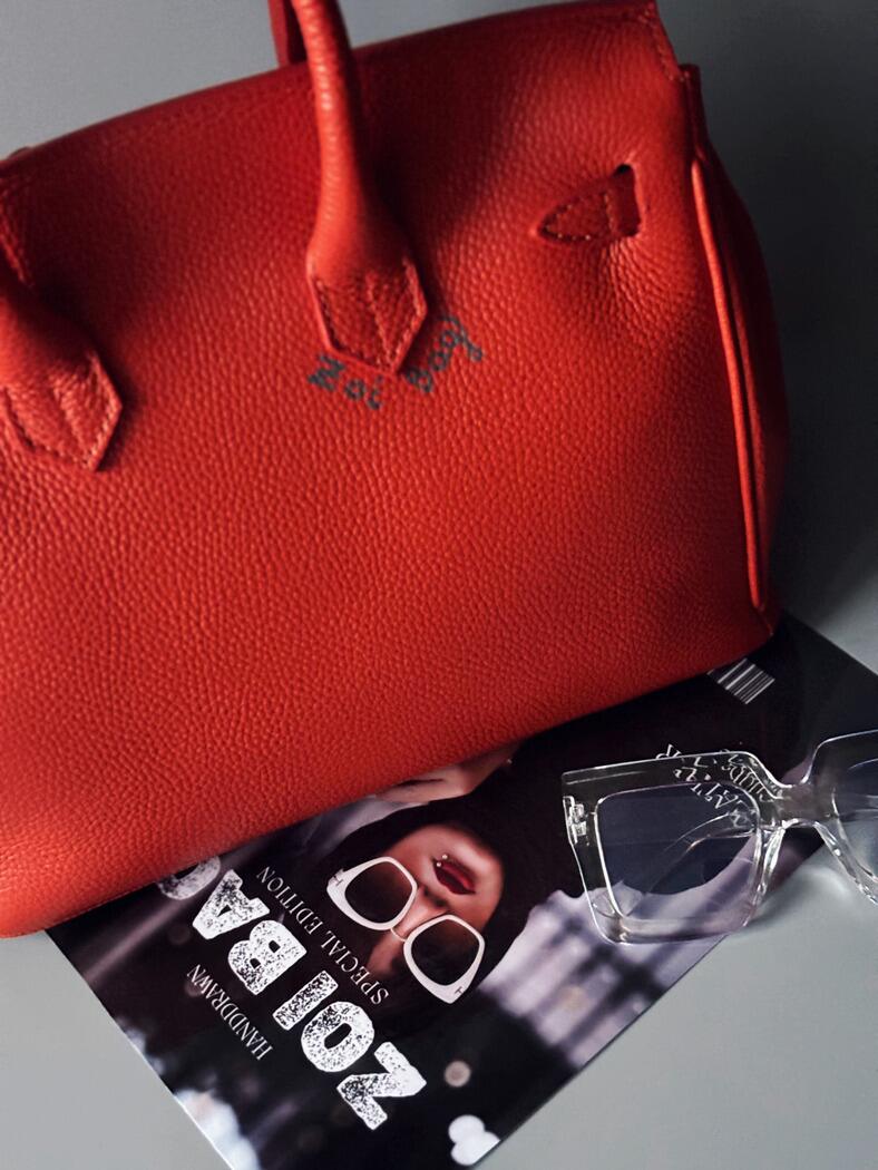 Oranžová kožená kabelka Zoi Bag s nápisem "Rebel Girl" zezadu