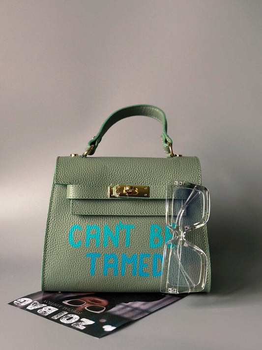 Pistáciová kožená crossbody Zoi Bag s ručně psaným nápisem "Can't be tamed"