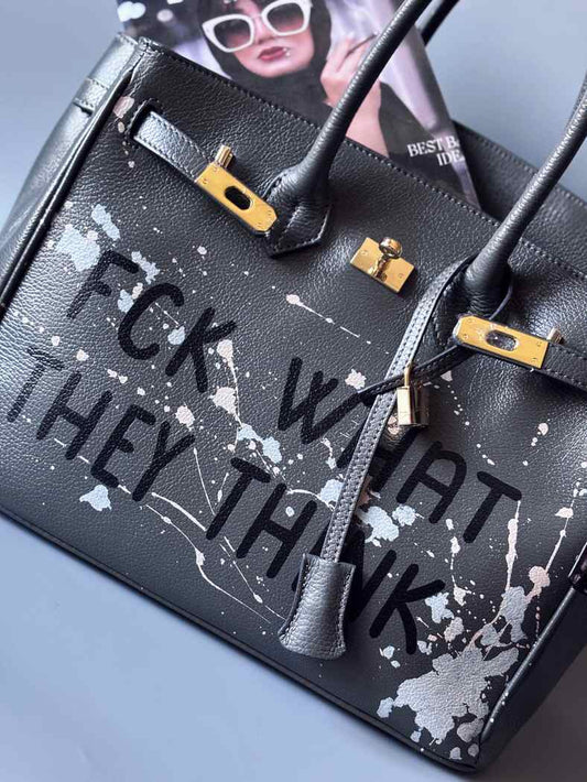 Designová luxusní šedá kožená kabelka Zoi Bag s ručně psaným nápisem a s cákanci barvou. Zapínání pomocí klíčku a zámku.