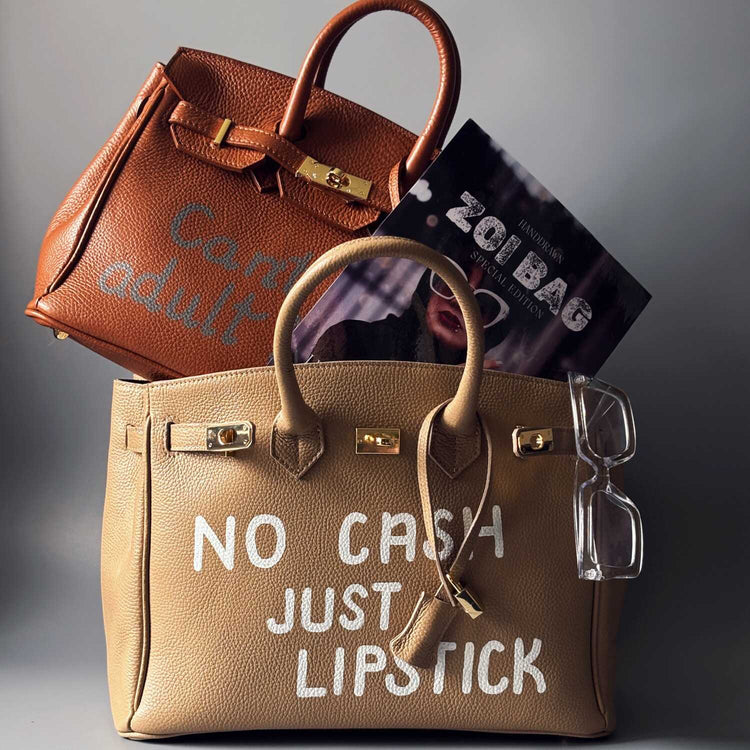 Fotografie dvou kožených art kabelek Zoi Bag s ručně psanými nápisy. 