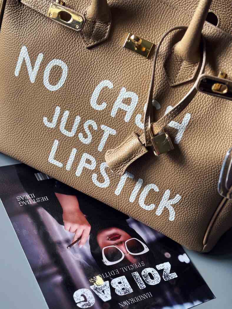 Velká béžová kožená kabelka Zoi Bag s nápisem "No cash, just lipstick" detail