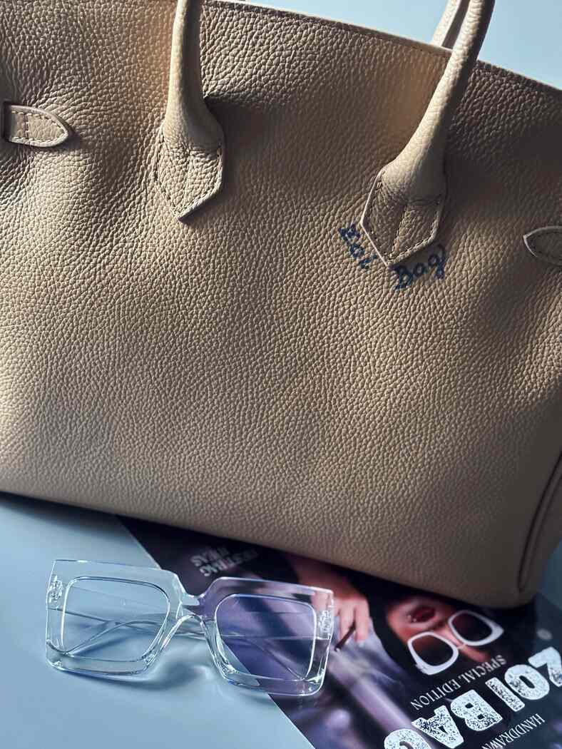 Art béžová kožená kabelka Zoi Bag s nápisem "No cash, just lipstick" zezadu