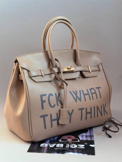 Unikátní designová kožená kabelka od Zoibag s ručně malovaným originální nápisem. Zapnutá pomocí zámku s klíčkem.