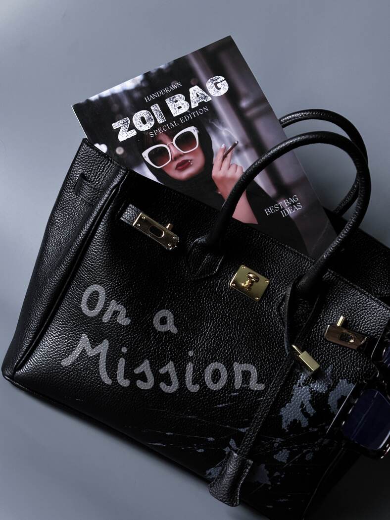 Velká černá kožená kabelka Zoi Bag s ručně psaným nápisem "On a Mission"