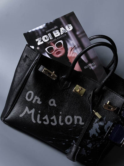 Velká černá kožená kabelka Zoi Bag s ručně psaným nápisem "On a Mission"