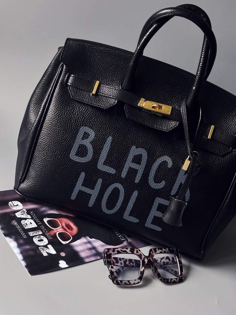 Černá velká kožená kabelka s ručně psaným nápisem "Black Hole" zapnutá