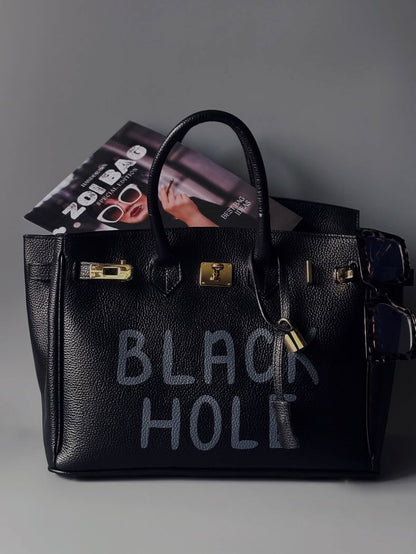 Černá velká kožená kabelka s ručně psaným nápisem "Black Hole"