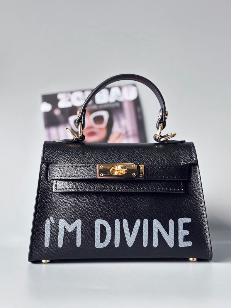 Designová luxusní černá kabelka s ručně psaným nápisem, elegantním otočným zámkem a odnímatelným crossbody popruhem.