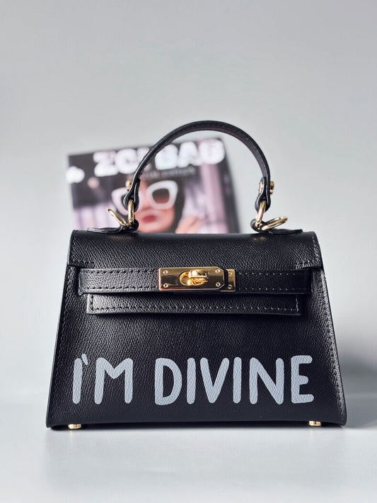 Designová luxusní černá kabelka s ručně psaným nápisem, elegantním otočným zámkem a odnímatelným crossbody popruhem.