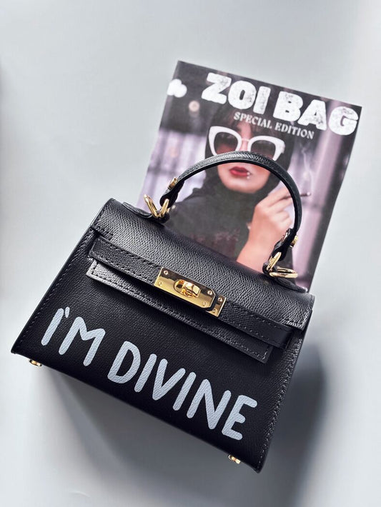 Designová luxusní černá kabelka s ručně psaným nápisem, elegantním otočným zámkem a odnímatelným crossbody popruhem.