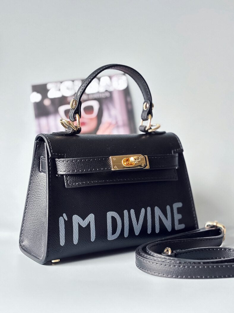 Designová luxusní černá kabelka s ručně psaným nápisem, elegantním otočným zámkem a odnímatelným crossbody popruhem.