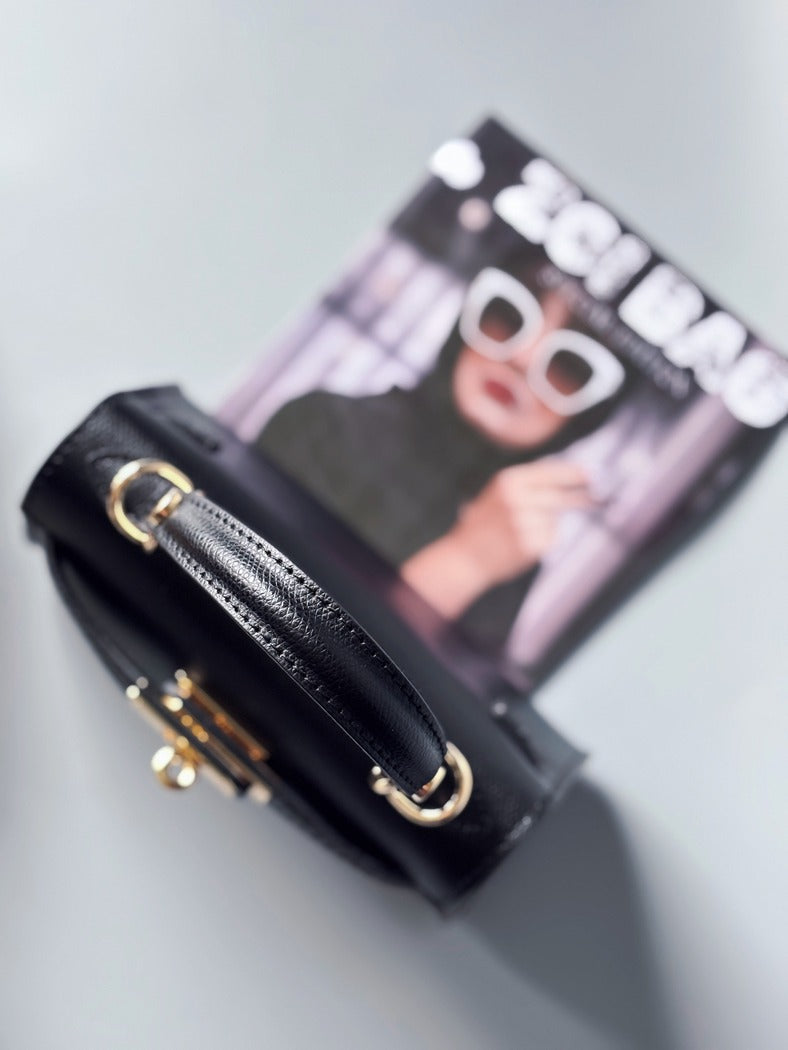 Designová luxusní černá kabelka s ručně psaným nápisem, elegantním otočným zámkem a odnímatelným crossbody popruhem.