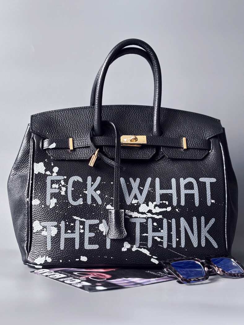 Luxusní designová kabelka Zoi Bag s ručně psaným nápisem a s cákanci barvou. Ikonické zapínání se zámkem a klíčkem. Zapnutá.