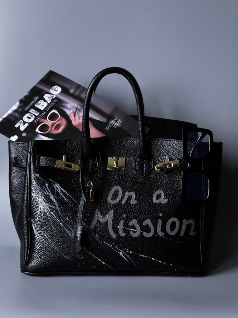 Velká černá kožená kabelka Zoi Bag s ručně psaným nápisem "On a Mision"