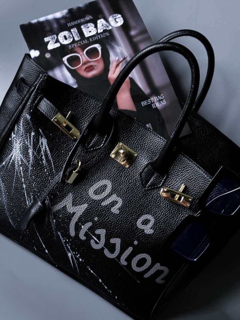 Stylová černá kožená kabelka Zoi Bag s ručně psaným nápisem "On a Mision"