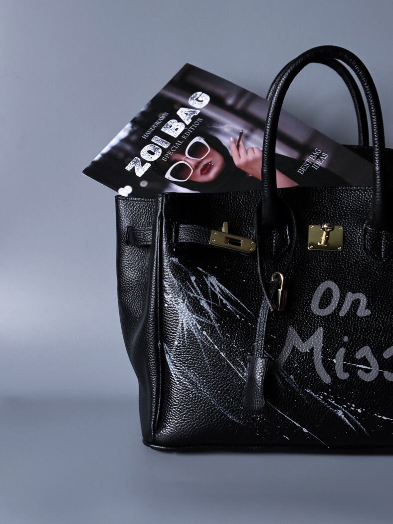 Extravagantní černá kožená kabelka Zoi Bag s ručně psaným nápisem "On a Mision"