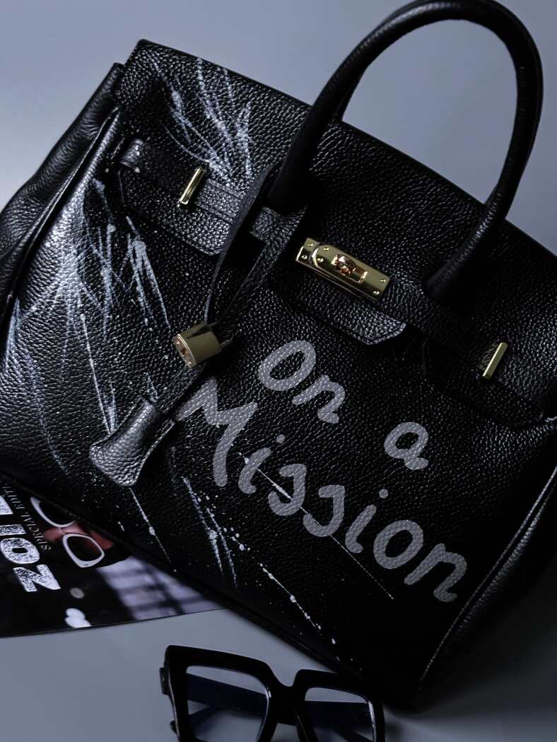 Černá kožená kabelka Zoi Bag s ručně psaným nápisem "On a Mision"