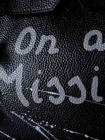 Černá kožená kabelka Zoi Bag s ručně psaným nápisem "On a Mision" detail nápisu