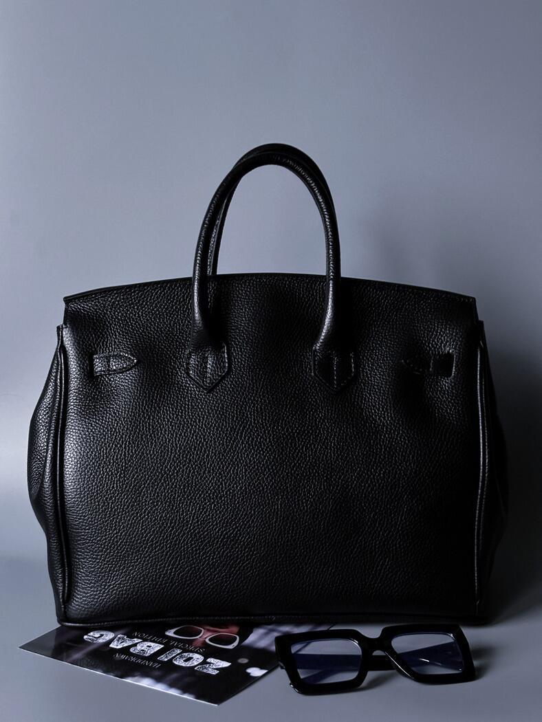 Černá kožená kabelka Zoi Bag s ručně psaným nápisem "On a Mision" zezadu