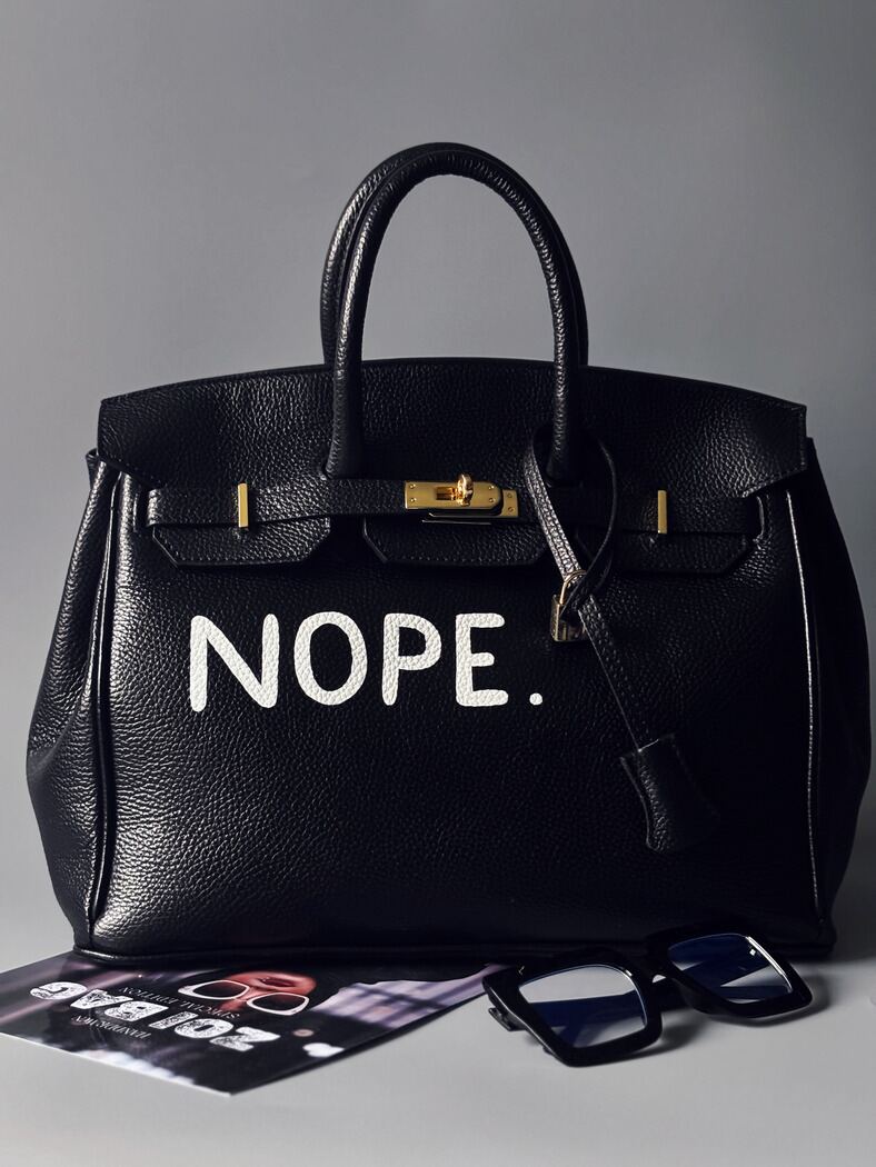 Černá kožená kabelka Zoi Bag, vyrobená z italské kůže s ručně psaným nápisem "Nope" zapnutá