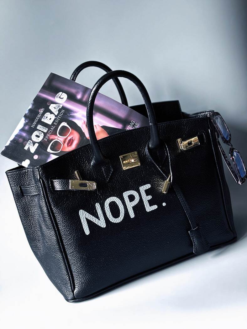 Černá kožená kabelka Zoi Bag s ručně psaným nápisem z pravé italské kůže se zapínáním pomocí ikonického zámku s klíčkem.