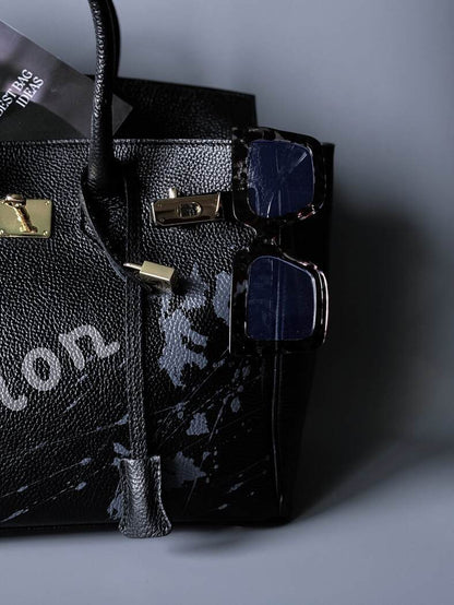 Velká černá kožená kabelka Zoi Bag s ručně psaným nápisem "On a Mission" detail cákanců