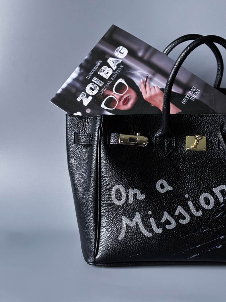 Velká černá kožená kabelka Zoi Bag s ručně psaným nápisem "On a Mission" detail nápisu