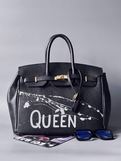 Designová luxusní kožená kabelka Zoi Bag s ručně psaným nápisem "Queen"a s cákanci barvou. Zapínání pomocí zámku a klíčku. Zapnutá.