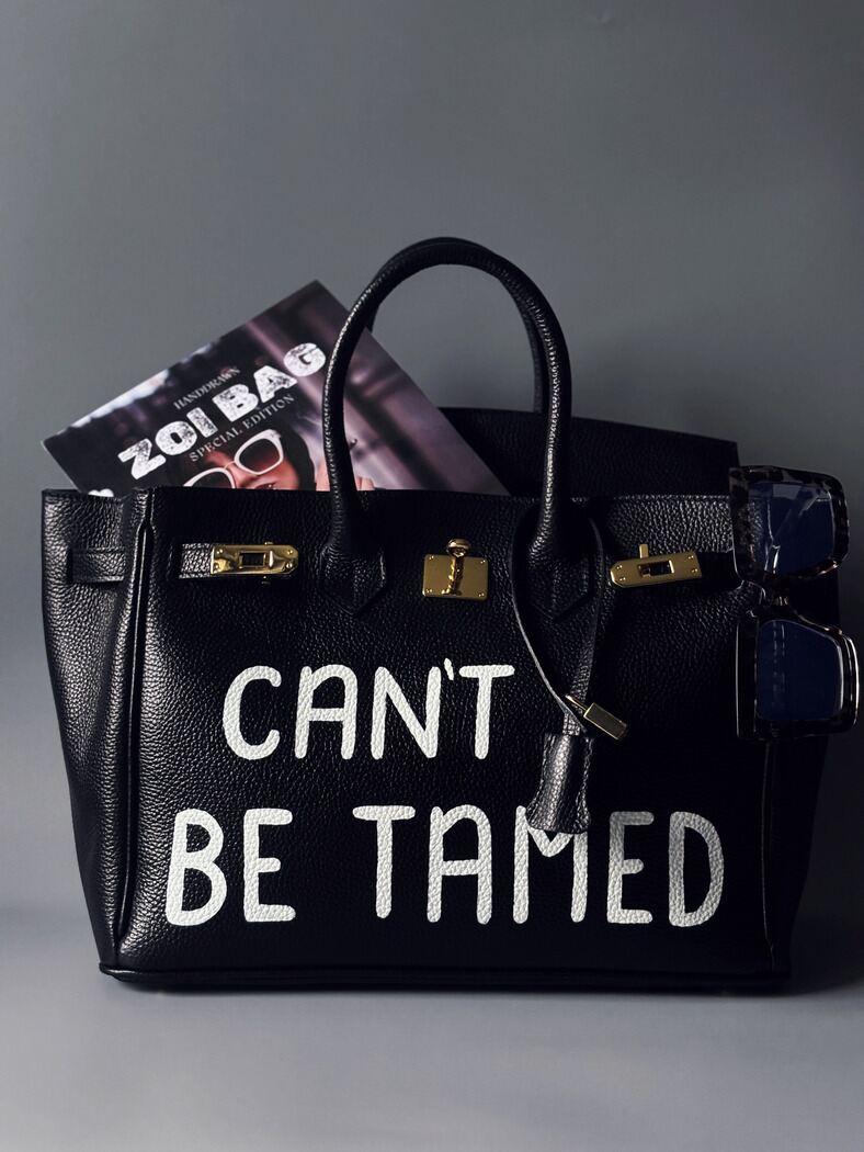 Luxusní černá dámská kabelka Zoi Bag z pravé italské kůže s ručně psaným nápisem "Can't be tamed"
