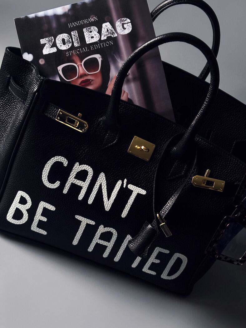 Elegantní černá dámská kabelka Zoi Bag z pravé italské kůže s nápisem "Can't be tamed" a zlatým zámkem s klíčkem