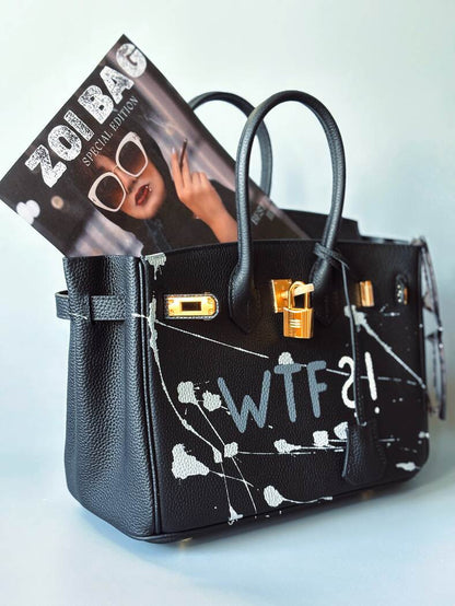 Designová černá kožená kabelka Zoi Bag z právé kůže s ručně psaným nápisem a cákanci barvou. Zlatý zámek s klíčkem.