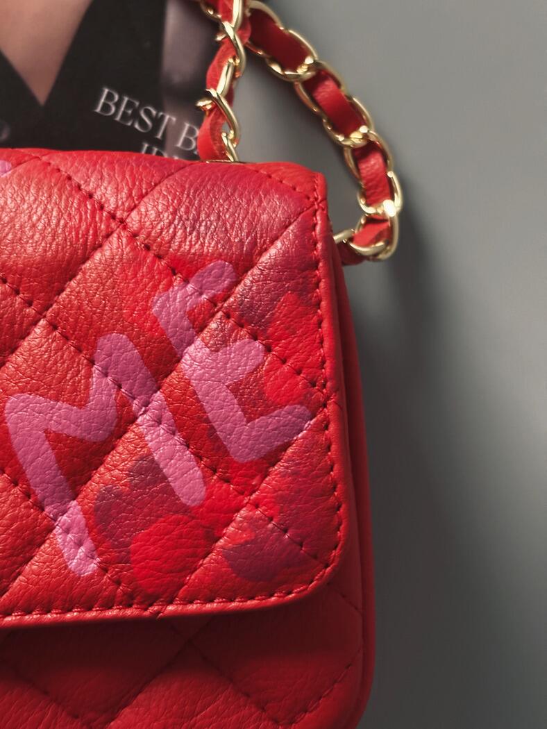 Červená crossbody kožená kabelka Zoi Bag s ručně psaným nápisem "Love Me" a s cákanci barvou - detail
