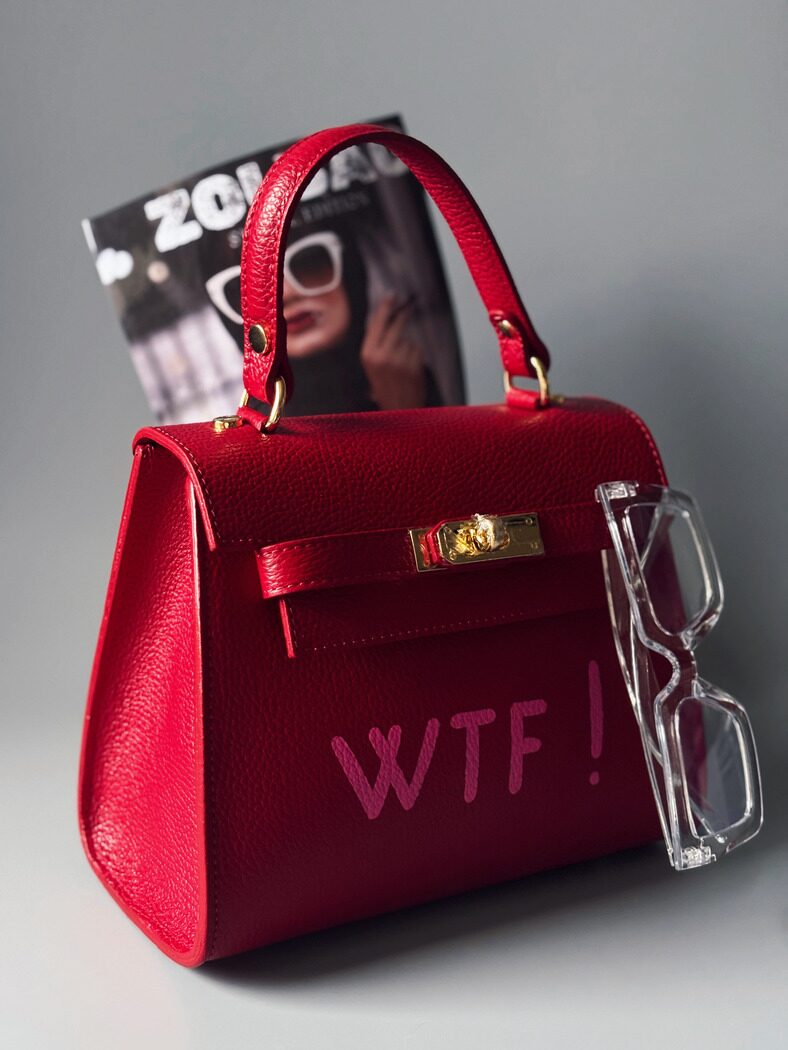 Sytě červená kabelka Zoi Bag s růžovým nápisem "WTF", vyrobená z pravé kůže - z boku