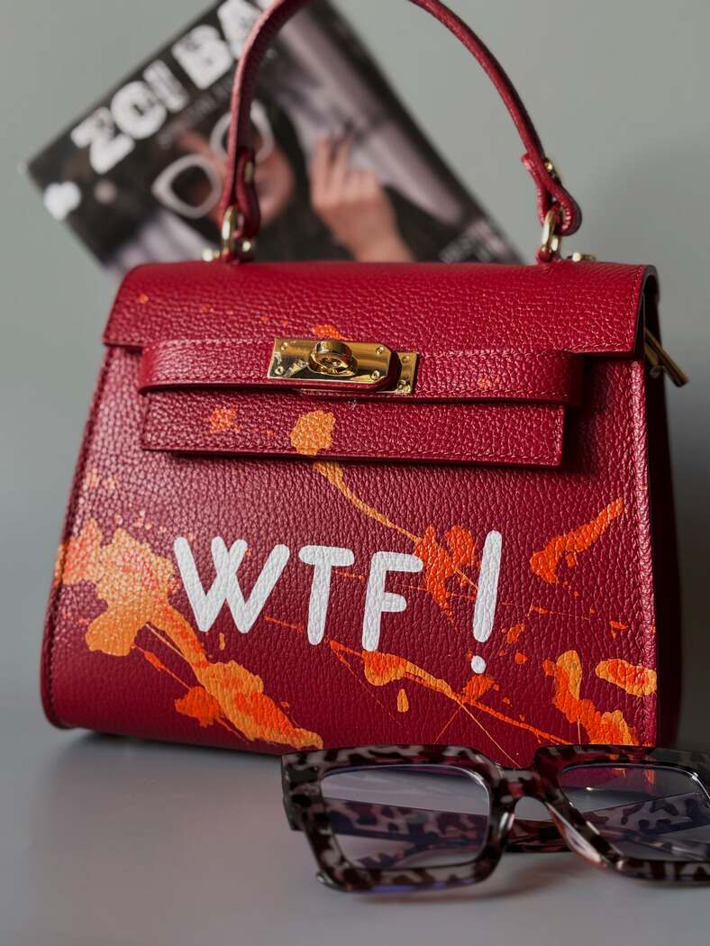 Designová červená crossbody kabelka Zoi Bag z pravé italské kůže s ručně psaným nápisem a cákanci barvou.