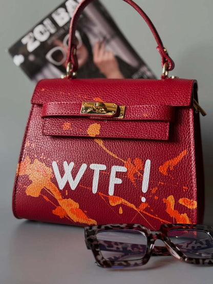 Designová červená crossbody kabelka Zoi Bag z pravé italské kůže s ručně psaným nápisem a cákanci barvou.