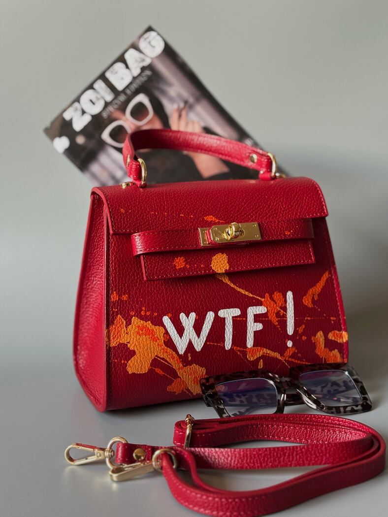 Designová červená crossbody kabelka Zoi Bag z pravé italské kůže s ručně psaným nápisem a cákanci barvou.