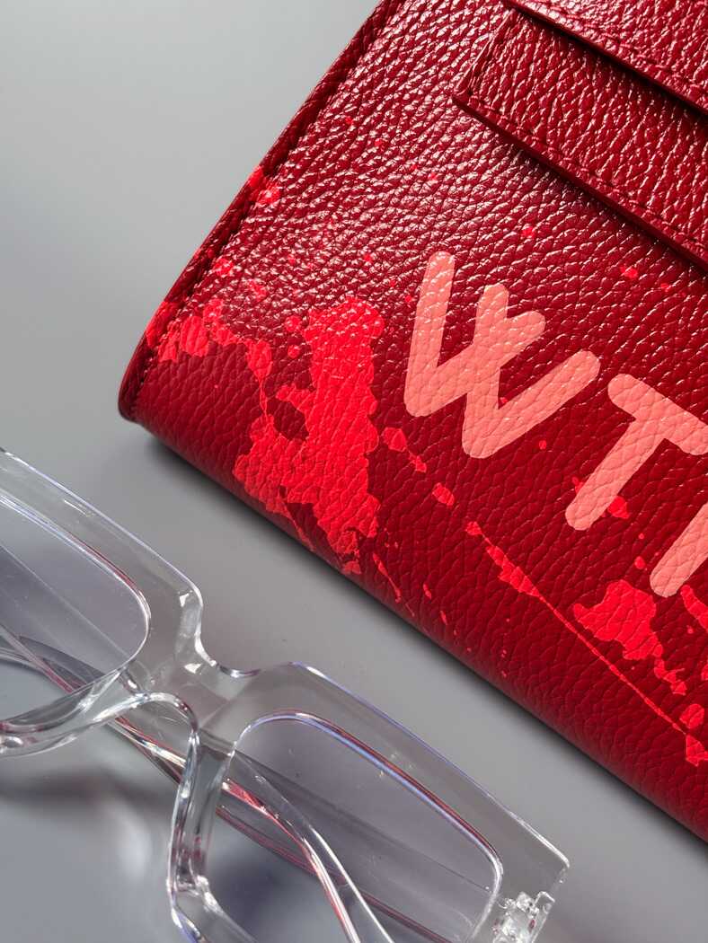 Červená designová  kožená kabelka Zoi Bag z pravé italské kůže s ručně psaným nápisem WTF a s cákanci barvou. Detail nápisu a cákanců.