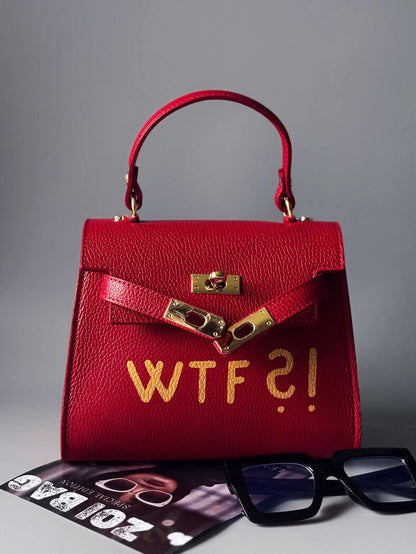 Čevená kožená kabelka Zoi Bag se zlatým nápisem"WTF" rozepnutá