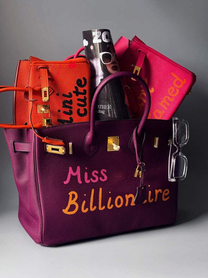Art fialová kožená kabelka Zoi Bag a nápisem "Miss Billionaire" s dalšími kabelkami