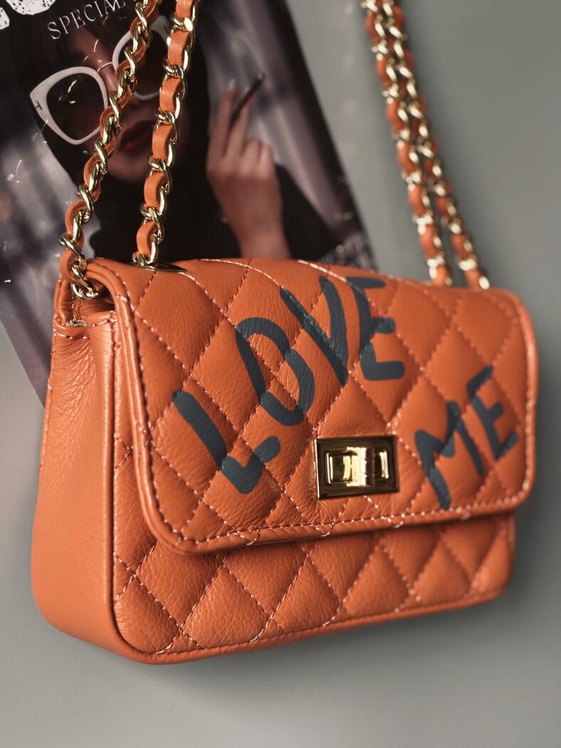 Hnědá kožená kabelka Zoi Bag s ručně psaným šedým nápisem "Love Me" z boku