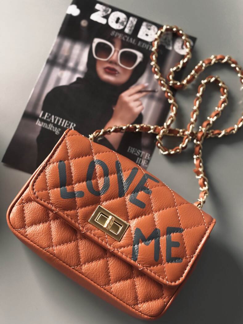 Hnědá kožená kabelka Zoi Bag s ručně psaným šedým nápisem "Love Me"