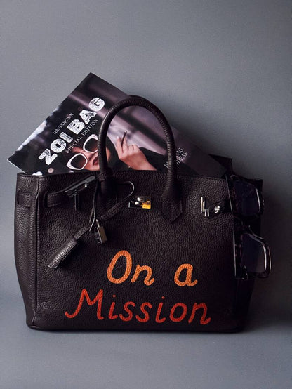 Art kožená kabelka Zoi Bag v hnědé barvě s nápisem "On a Mission"