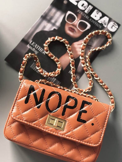 Hnědá kožená crossbody kabelka Zoi Bag s ručně psaným černým nápisem "Nope"