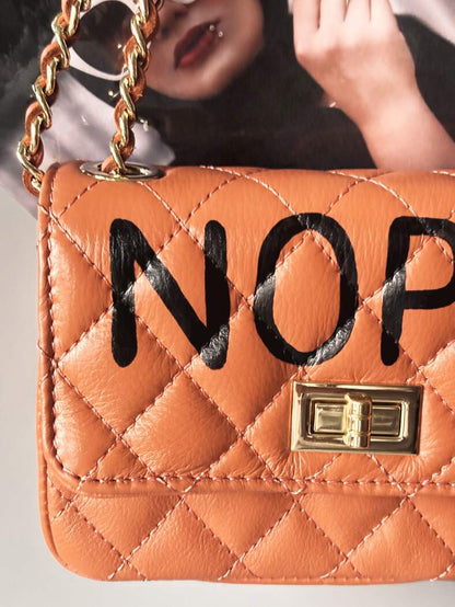 Hnědá kožená crossbody kabelka Zoi Bag s ručně psaným černým nápisem "Nope" detail nápisu
