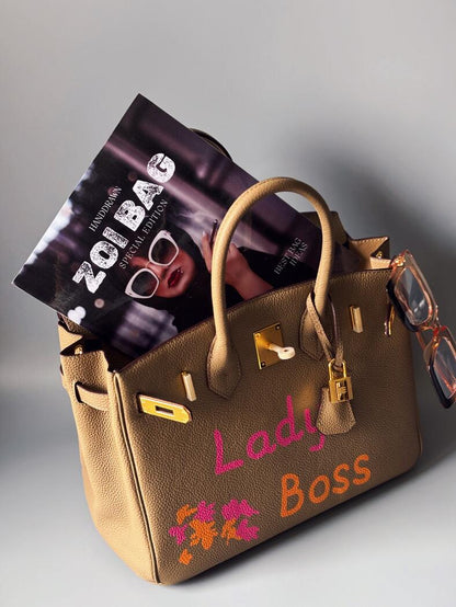 Kožená kabelka Zoi Bag v béžové barvě s nápisem "Lady Boss"