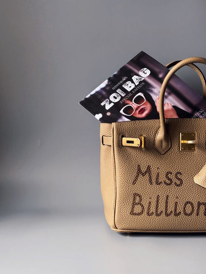 Kožená béžová kabelka Zoi Bag s nápisem "Miss Billionaire" detail